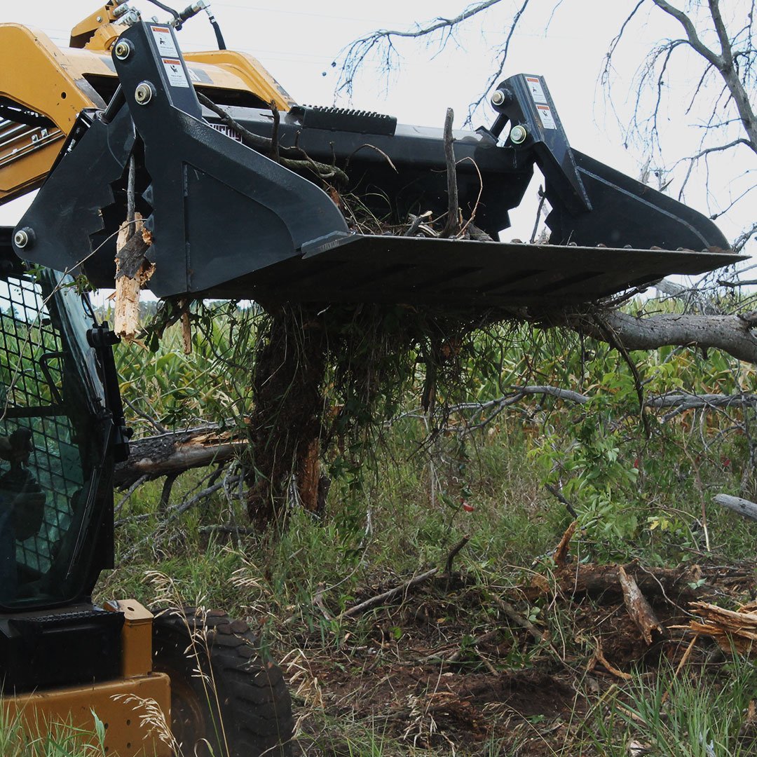 Multi-purpose bucket attached to skid steer picking up sticks and debris