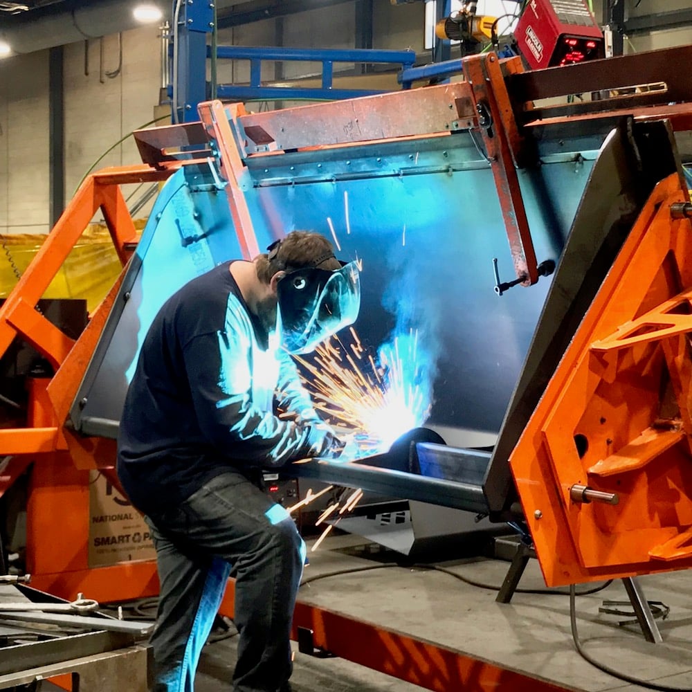 Virnig welder constructing bucket attachment 