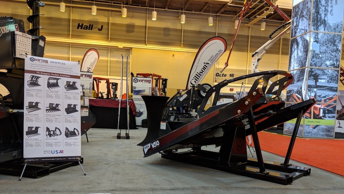 Image description: Virnig's trade show booth setup featuring a brush cutter skid steer attachment in the foreground.